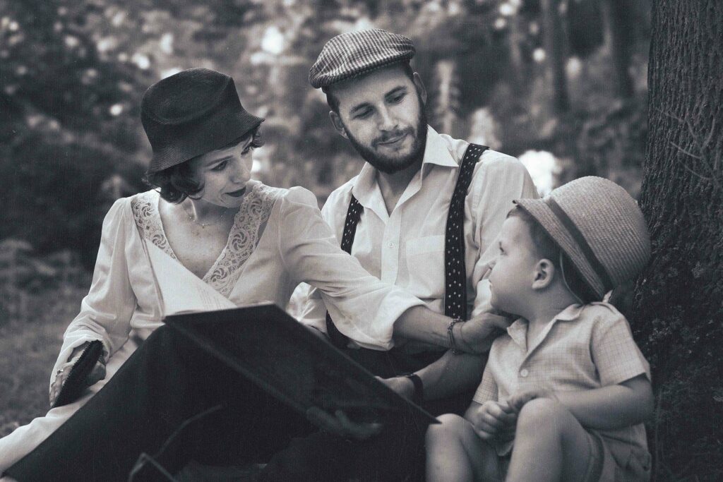 portrait d'un couple assis dans les bois, avec leur bébé, ambiance année 40