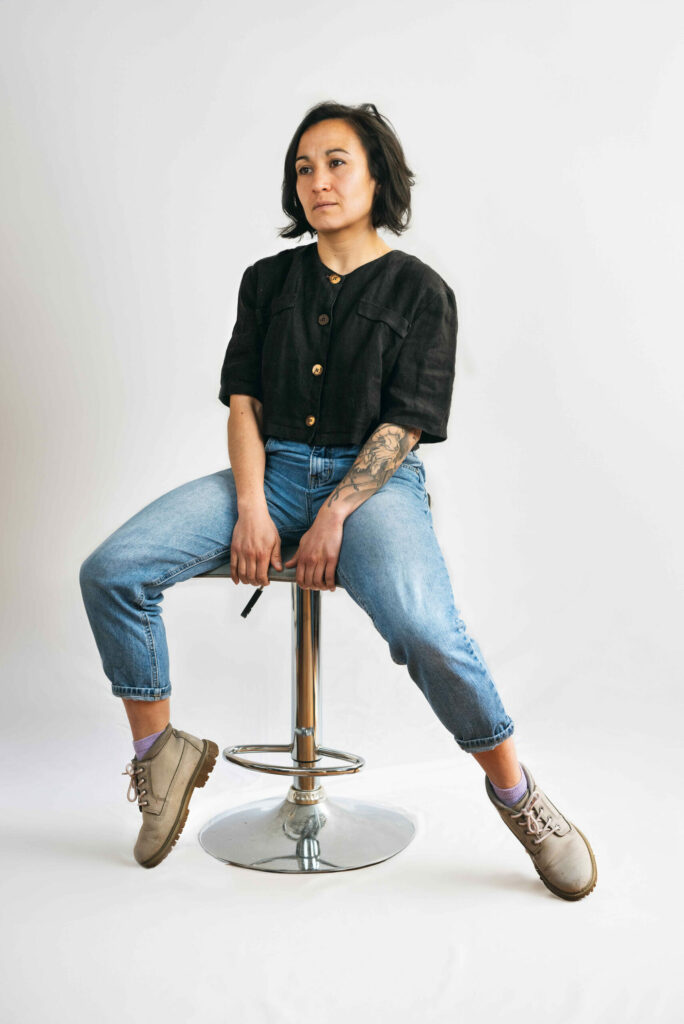 portrait en-pied d'une danseuse assise sur un tabouret, style naturel et professionnel
