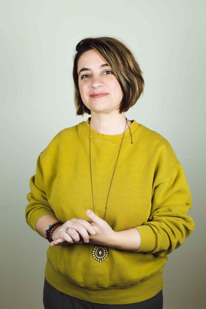 portrait naturel d'une femme souriante portant un pull jaune, photo professionnelle de type LinkedIn