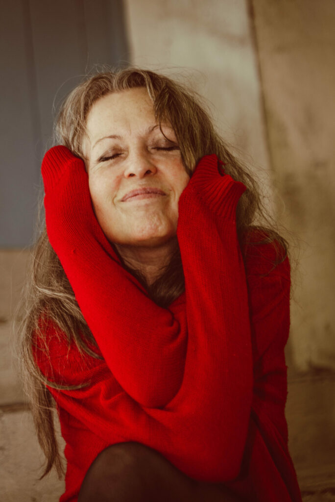 Portrait souriant d'une femme vêtue d'un pull rouge