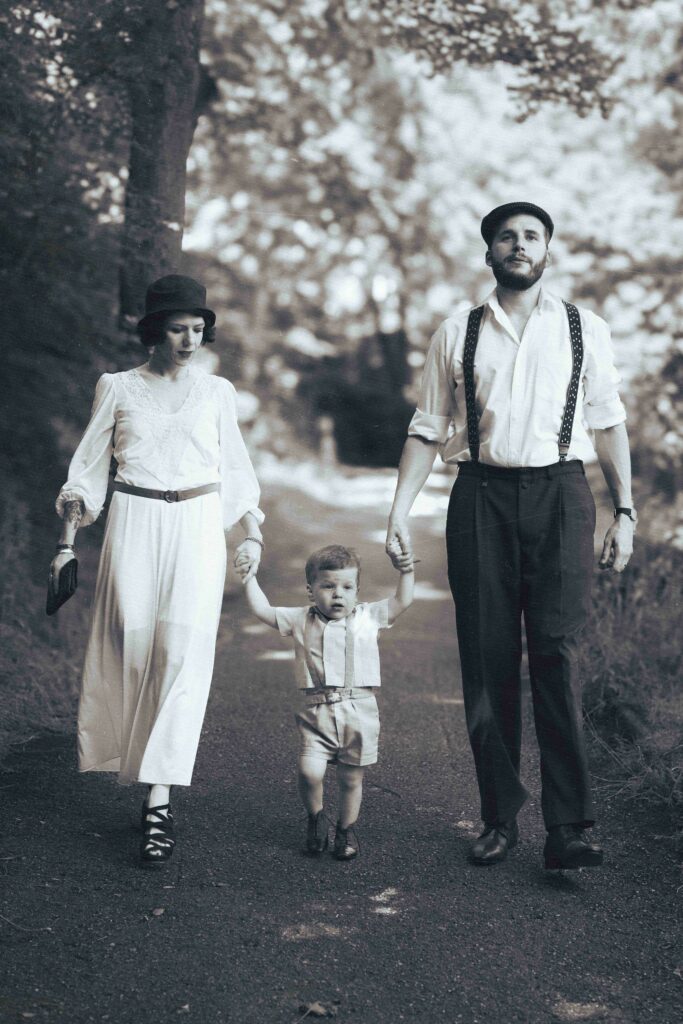portrait noir et blanc d'un couple et leur enfant qui marchent en se tenant la main, ambiance années 40