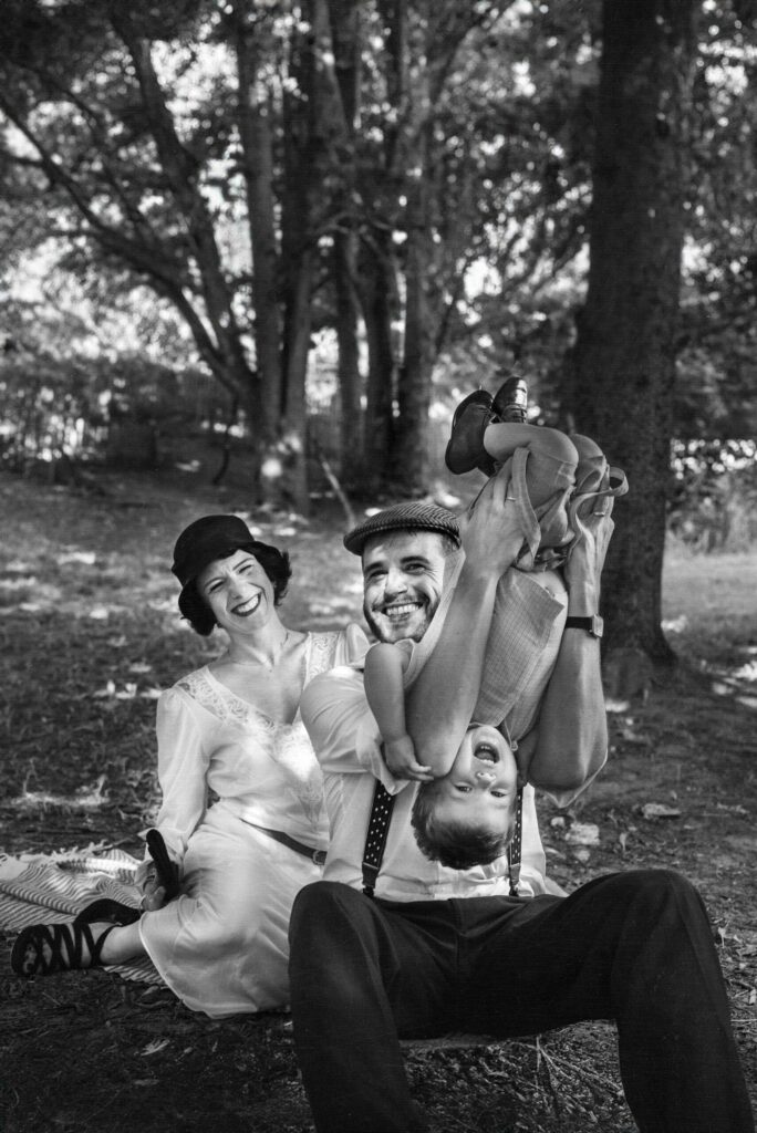 portrait noir et blanc d'un couple qui sourient et jouent avec leur fils, ambiance années 40
