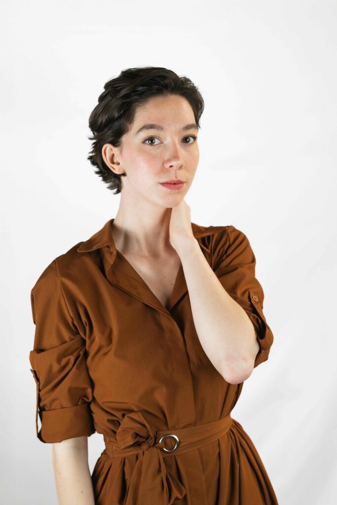 portrait pola d'une comédienne aux cheveux courts portant une robe marron, style naturel