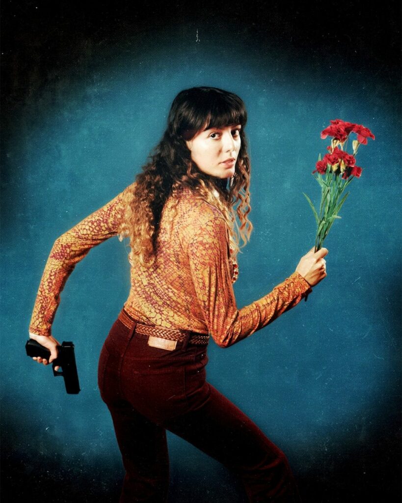 Portrait photo d'une femme tenant un revolver et un bouquet de roses
